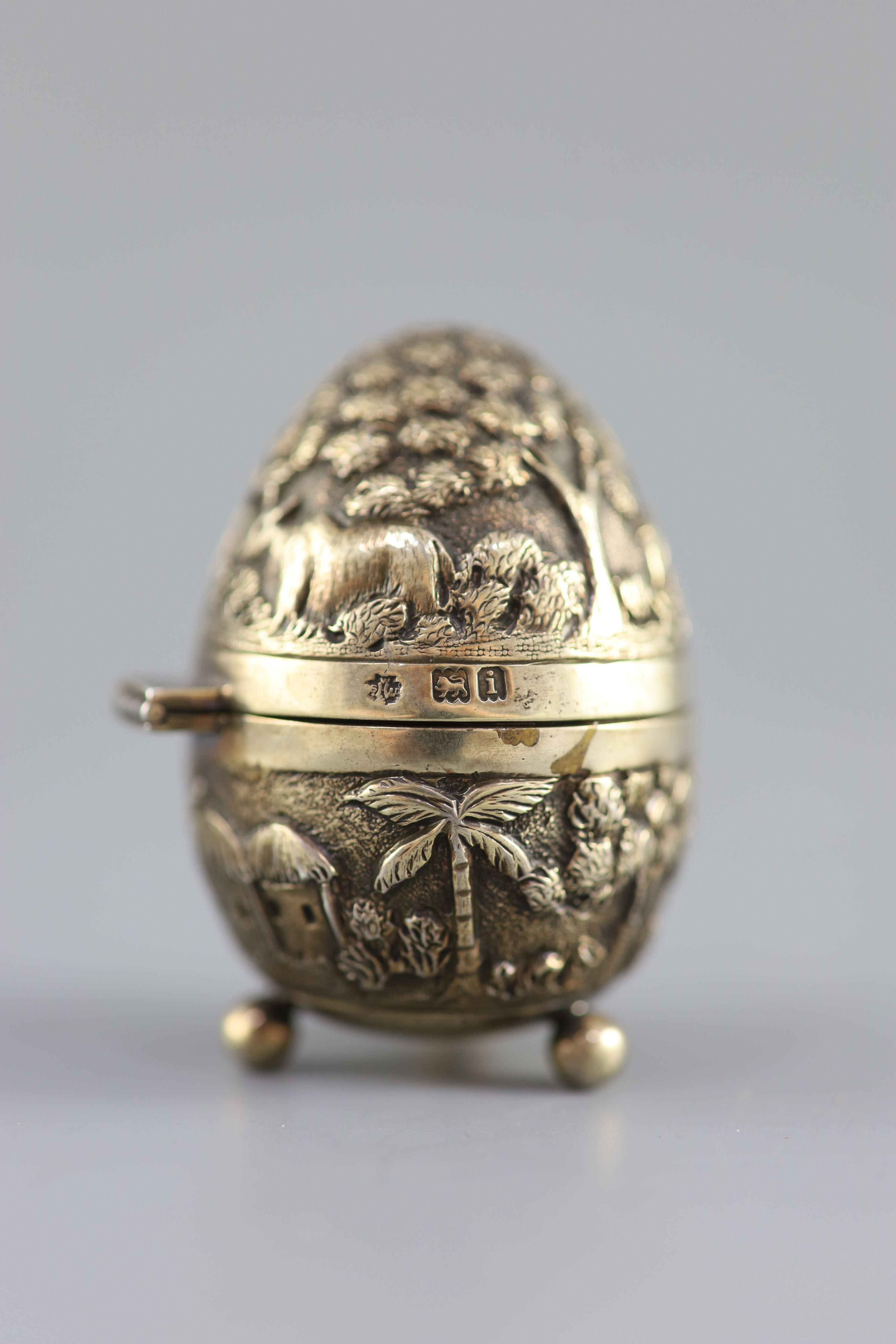 A graduated pair of Edwardian novelty silver gilt condiments, modelled as eggs, with bird's nest interior including two 'marbled' eggs